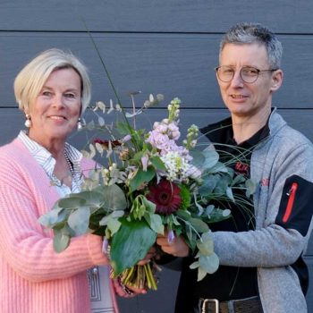 Anke Ringel bekommt von Torsten Allmendinger zum Jubiläum einen Blumenstrauß überreicht.