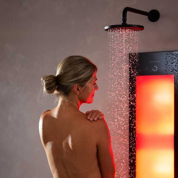 Frau steht in der Sunshower Dusche und entspannt ihre Muskeln durch das wärmende Infrarot-Licht